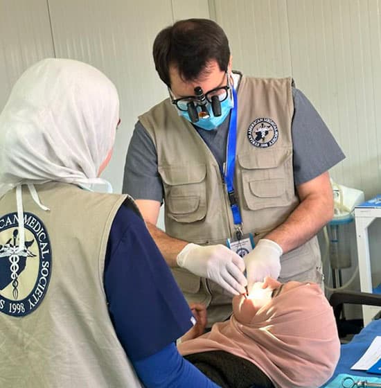 Dr. Atassi treating a patient at a refugee clinic with the Syrian American Medical Society