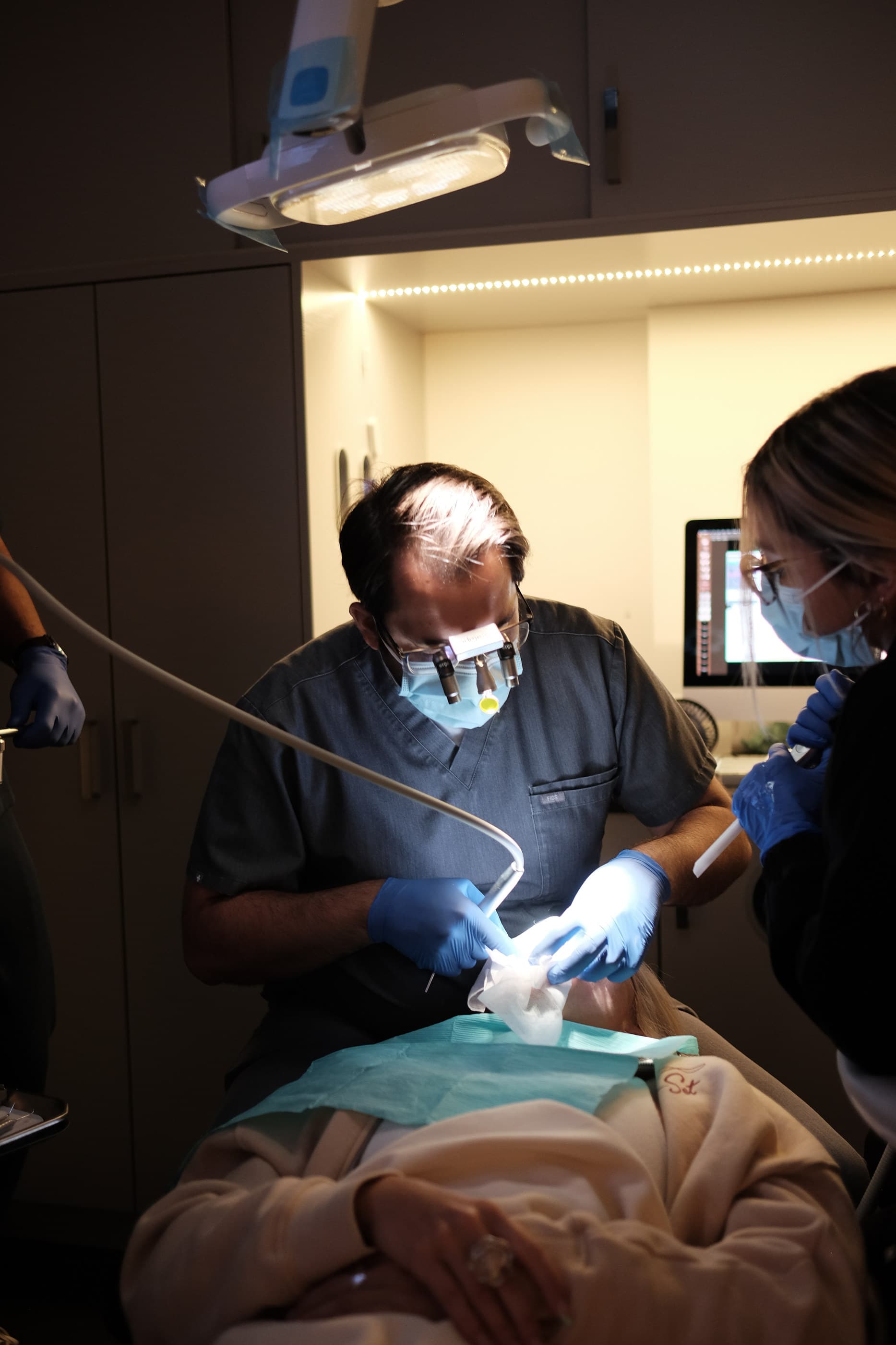 Dr. Atassi at work under the light with his assistant